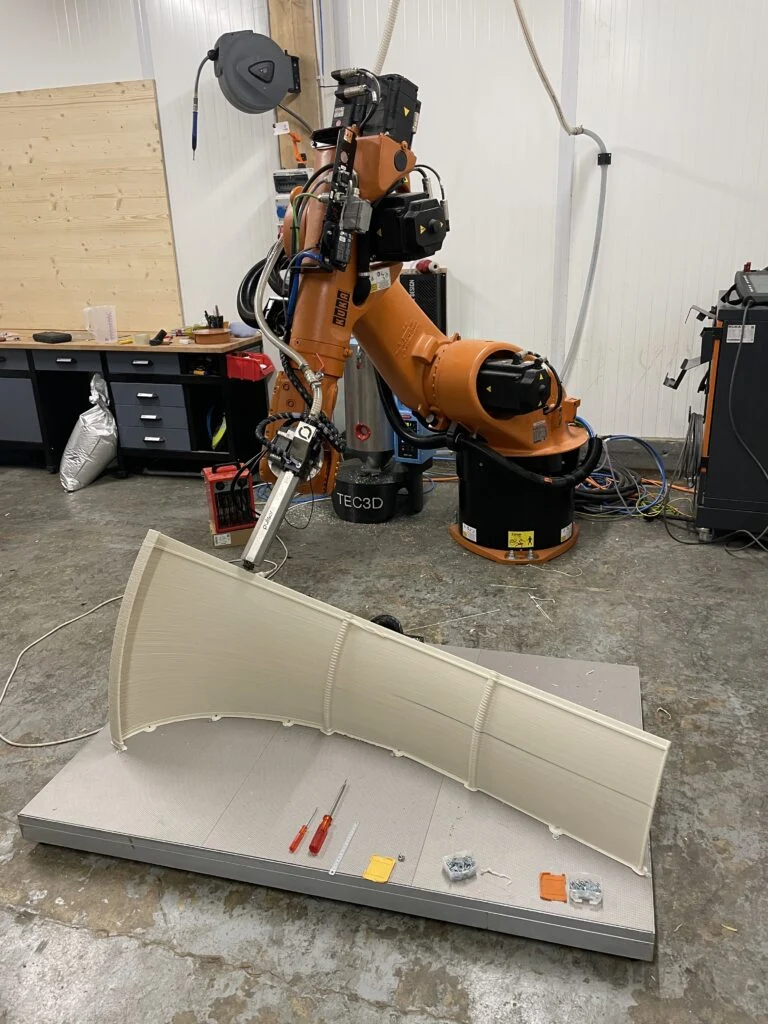 Élément courbe grand format devant le robot à l’atelier