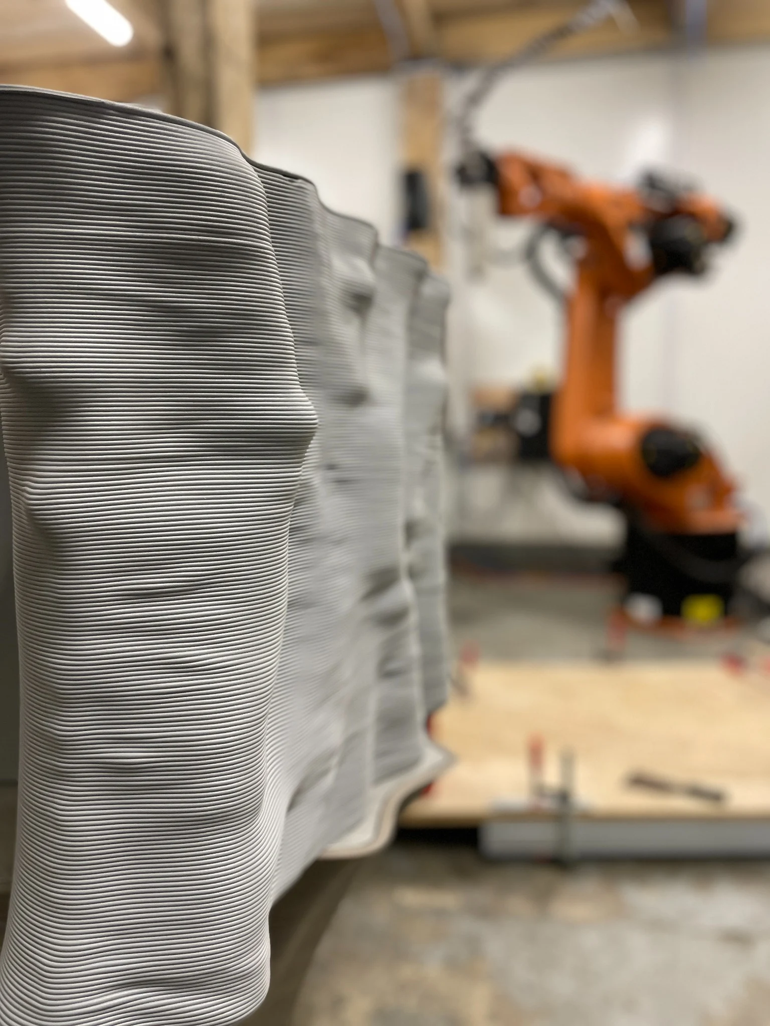 Pièce fabriquée couche par couche, avec le robot de production en arrière-plan
